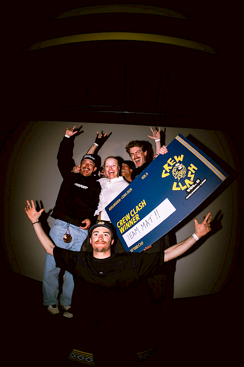 Team Mate celebrates their Crew Clash win with a large sign and joyful gestures.