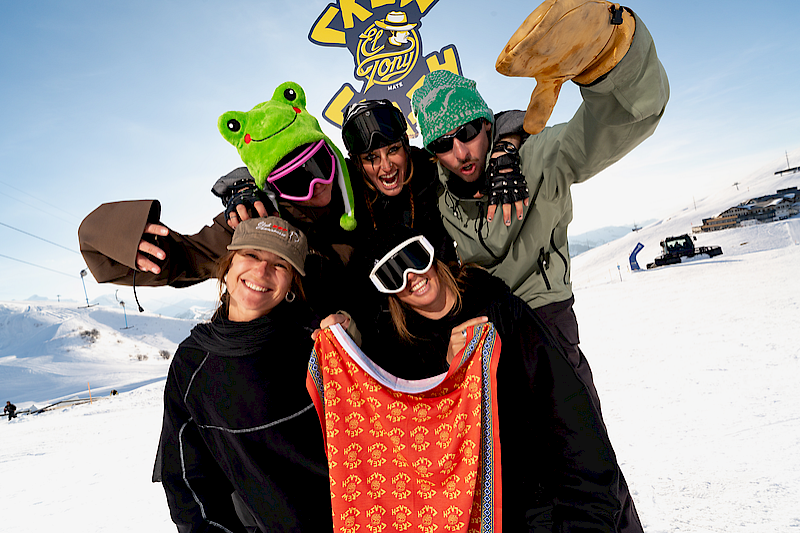 People in the snow with El Tony Mate, ski gear, and a cheerful vibe.