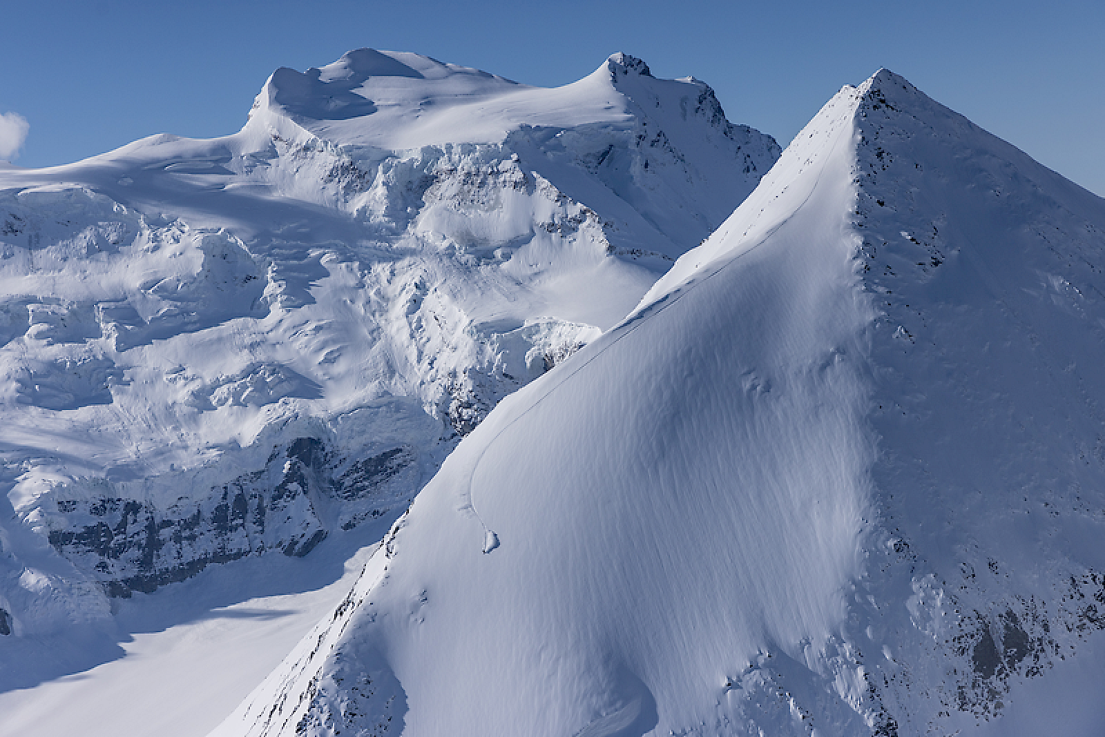 Schneebedeckte Berge in der Berglandschaft mit klarem blauen Himmel. Jérôme Caroli am freeriden.