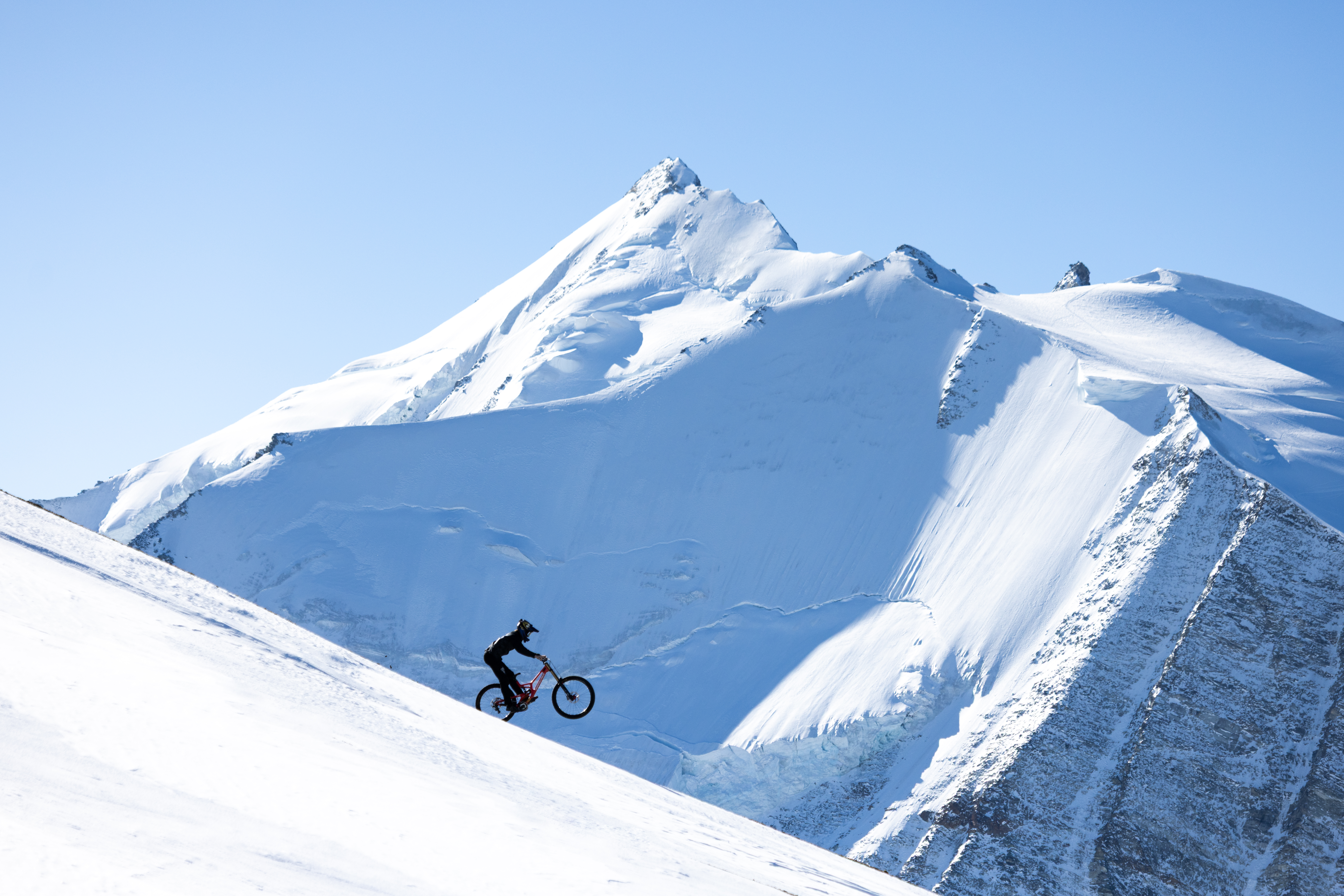 Ein Radfahrer und ein Skifahrer kombinieren ihre Sportarten im Schnee.