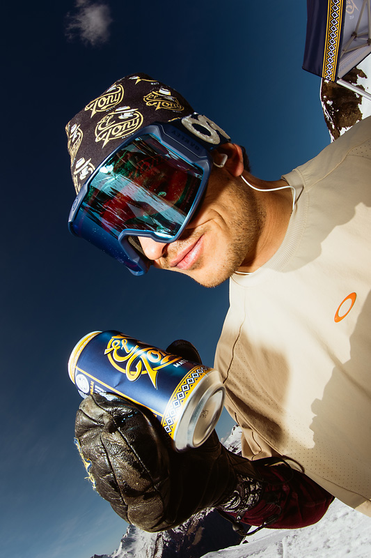 Man in skibril houdt El Tony Mate drankje vast in de bergen.