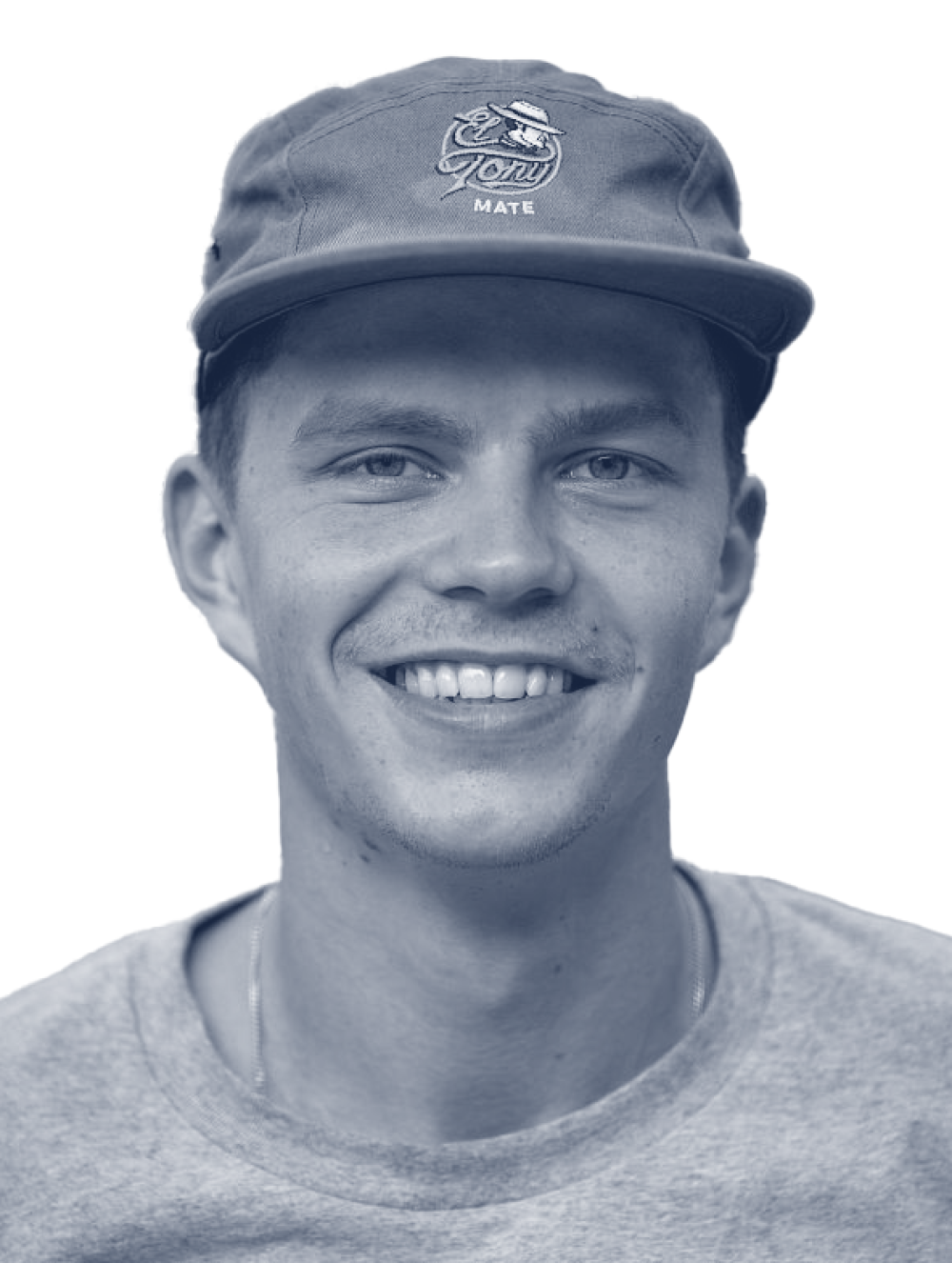 Un jeune homme avec une casquette El Tony Mate sourit chaleureusement à l'appareil photo.