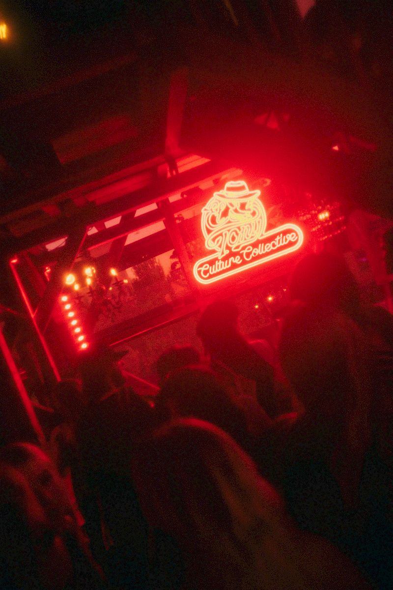 Insegna al neon rosso che dice 'Culture Collective' in un'atmosfera vivace.
