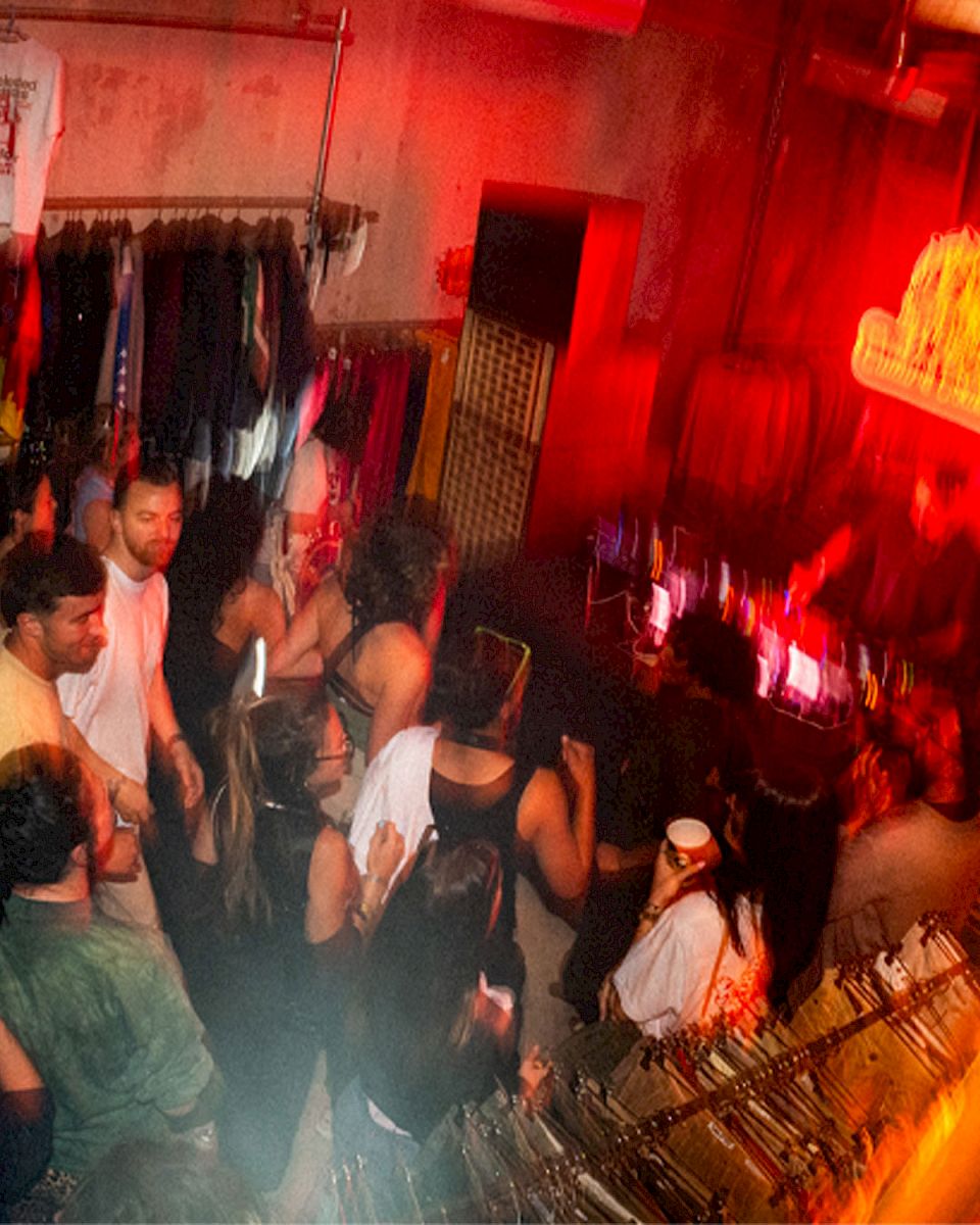 Een levendige feestscene met mensen die dansen en drankjes vasthouden.