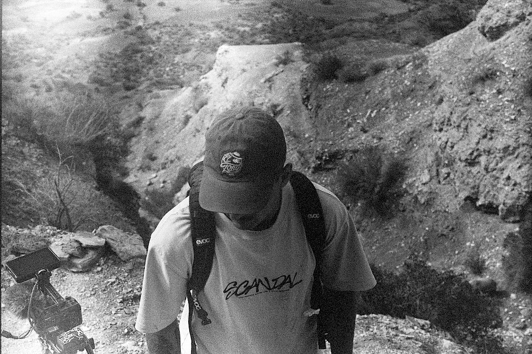 Un uomo con cappello e maglietta in natura, mentre gusta una bevanda El Tony Mate.