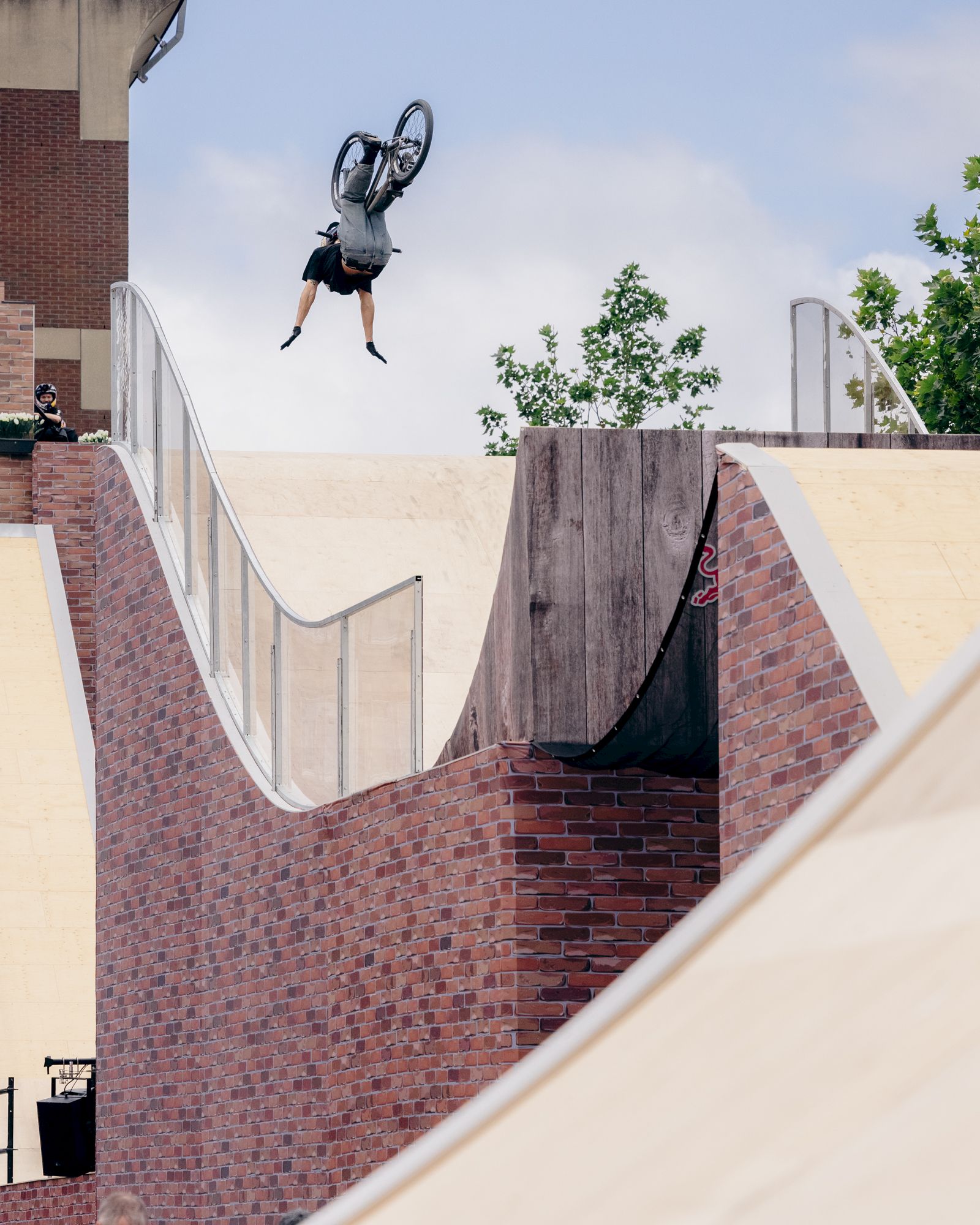Ciclista esegue un backflip su una rampetta in uno skatepark.