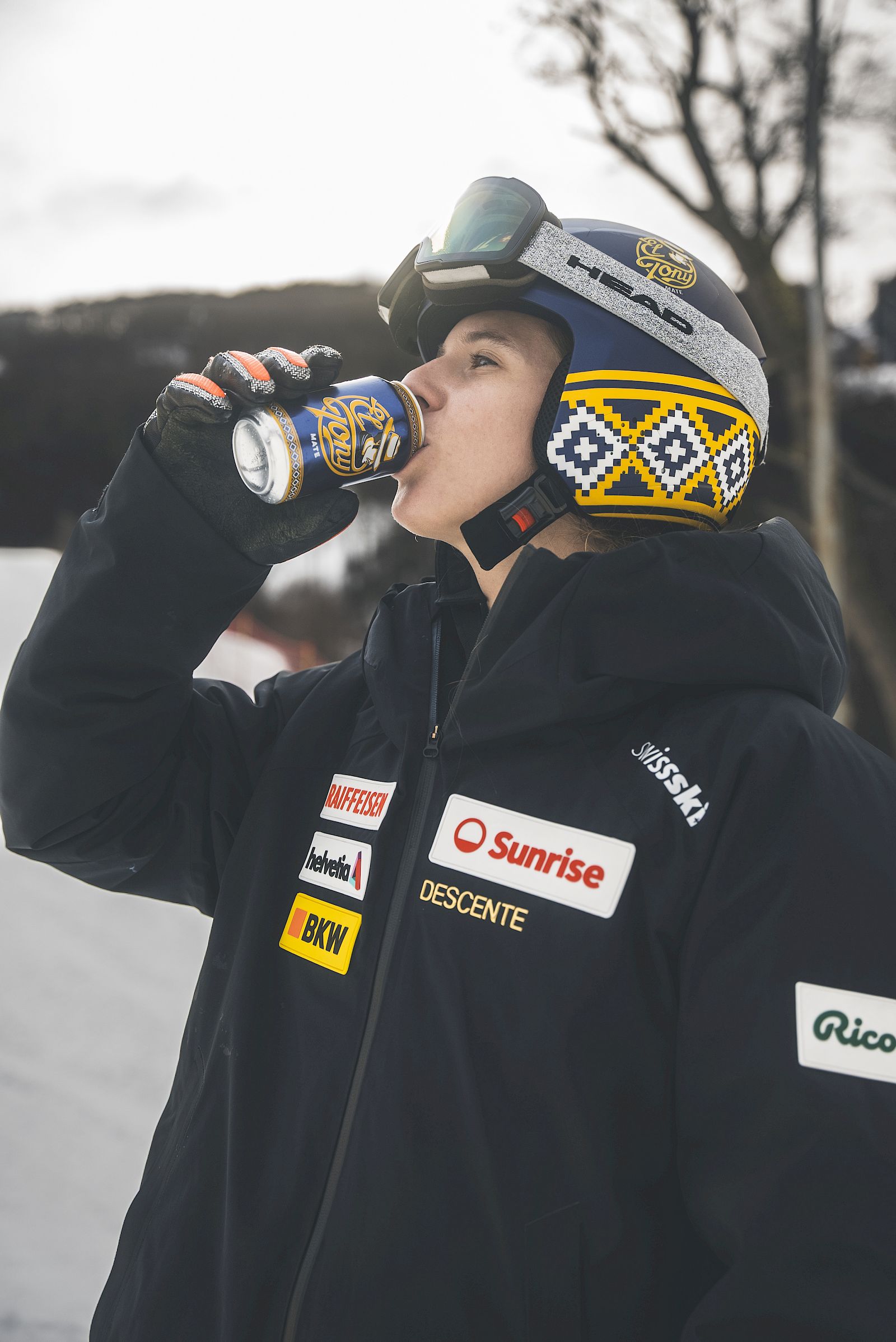 Junger Snowboarder trinkt El Tony Mate aus einer Dose in den Bergen.